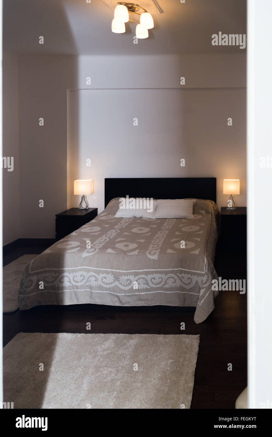 Geräumige Luxus moderne Doppelzimmer mit harten Holz Möbel. Komfortable Hotelzimmer braune Farbe Interieur, große weiße gemütliches Bett w Stockfoto