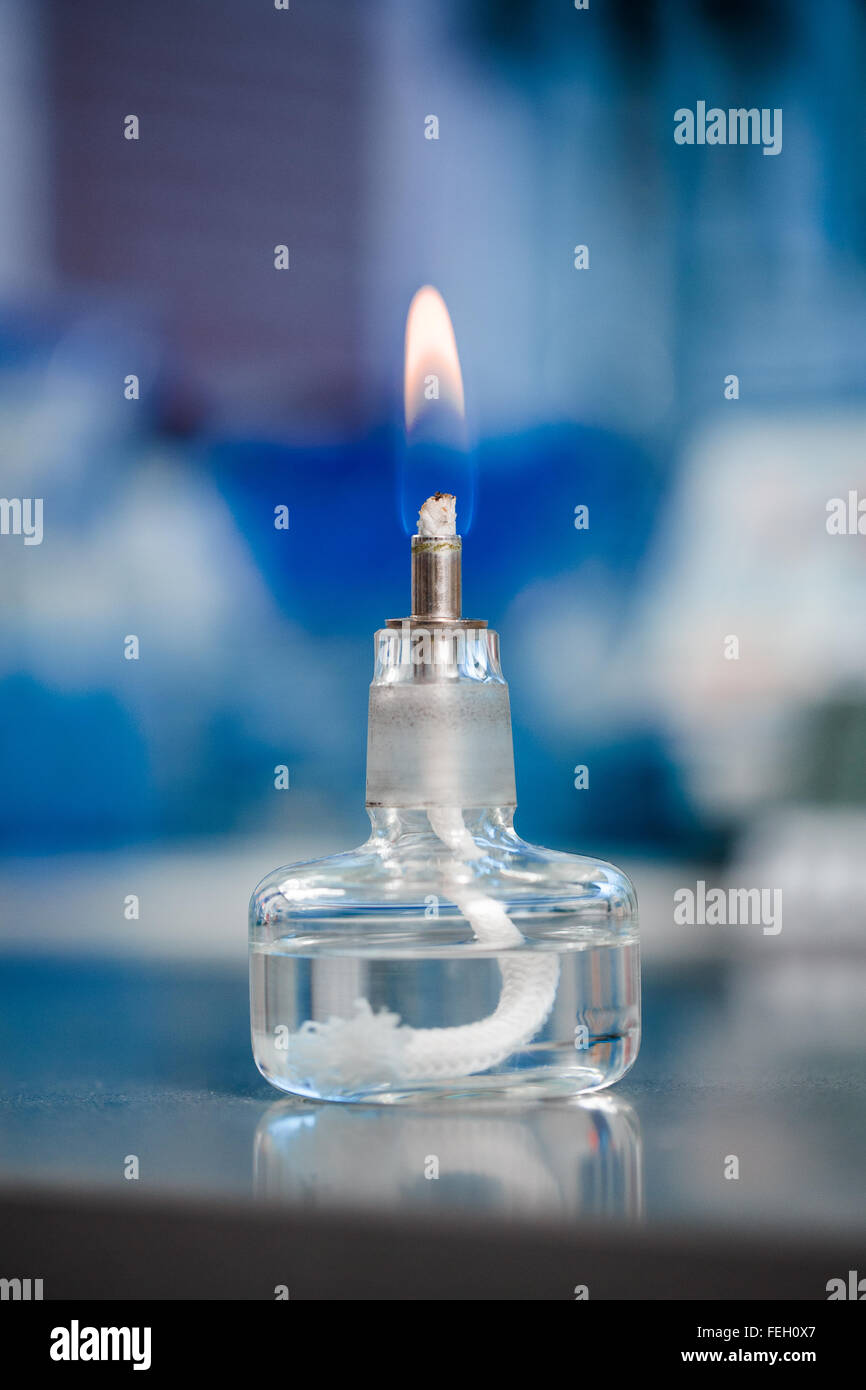 Kleines Glas-Brenner für chemische Experimente auf blauem Hintergrund Stockfoto