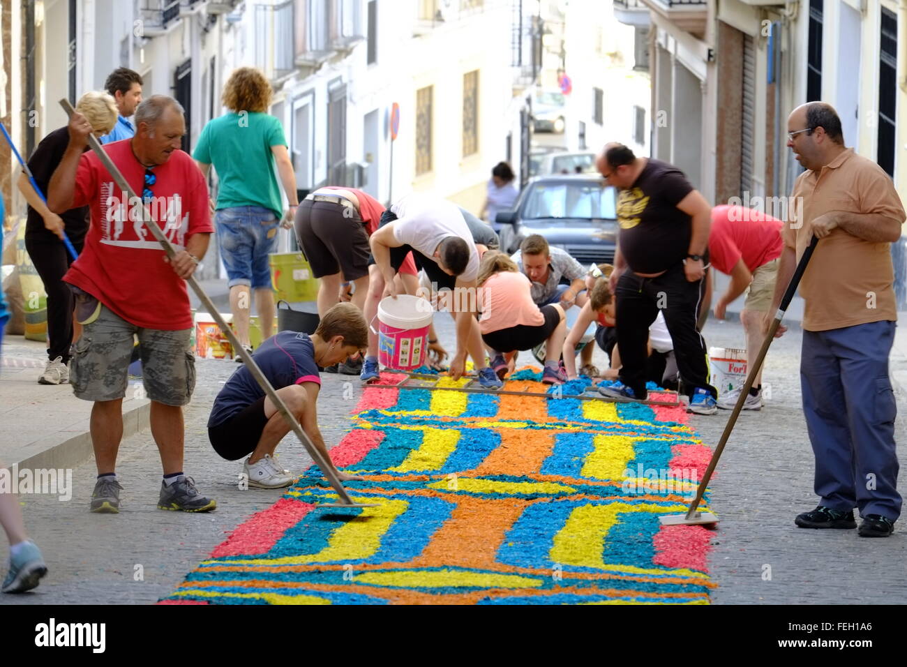 Fronleichnam. Die Dorfbewohner legen am Gründonnerstag traditionelle Teppiche aus farbigem Sägemehl auf ihre Straße. Carcabuey, Andalusien, Spanien Stockfoto