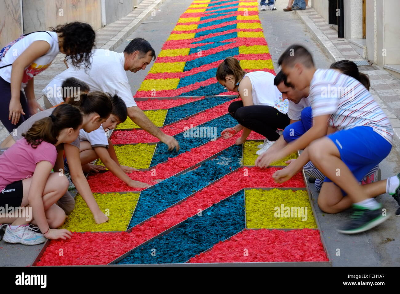 Fronleichnam. Die Dorfbewohner legen am Gründonnerstag traditionelle Teppiche aus farbigem Sägemehl auf ihre Straße. Carcabuey, Andalusien, Spanien Stockfoto