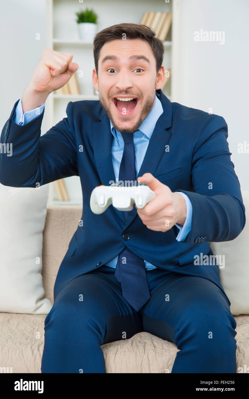 Schöner junger Mann in Anzug mit Videospielen Stockfoto