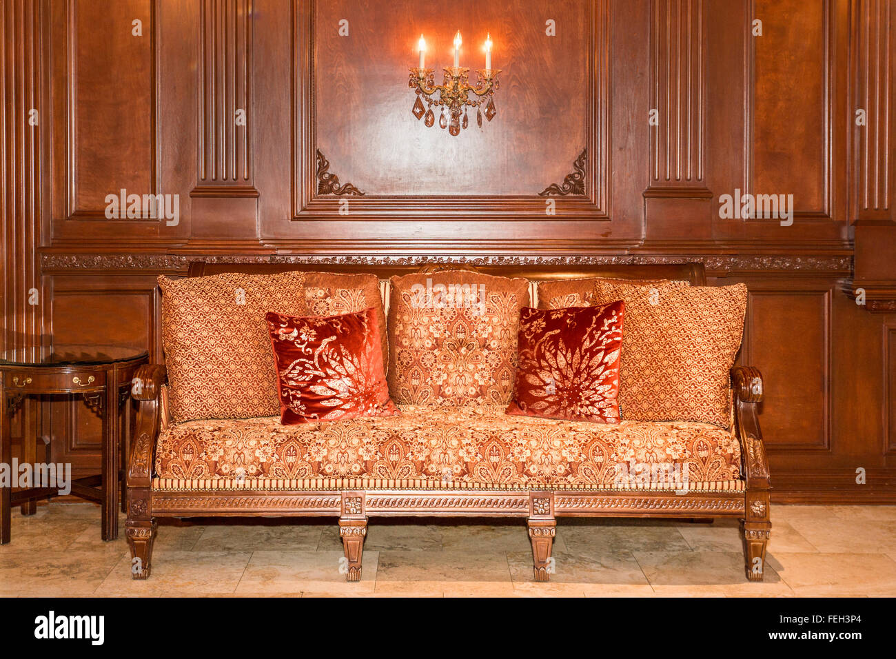 Sofa im traditionellen Stil gegen eine Kirsche Holz vertäfelten Wand Stockfoto