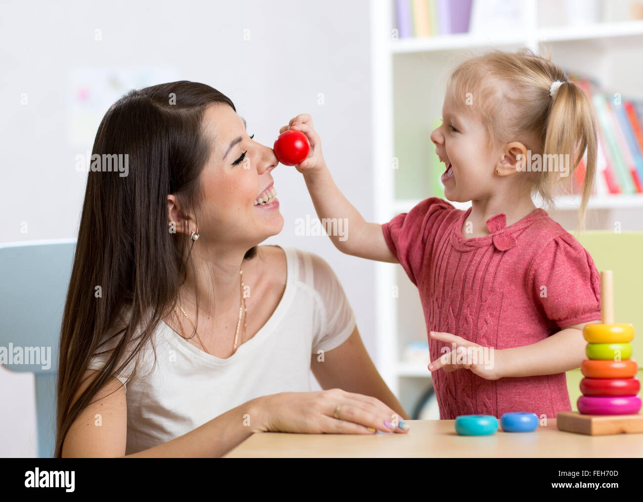 Lächelnde Mutter und Kind Tochter in den Kindergarten, glückliche Zeit und Zweisamkeit Stockfoto