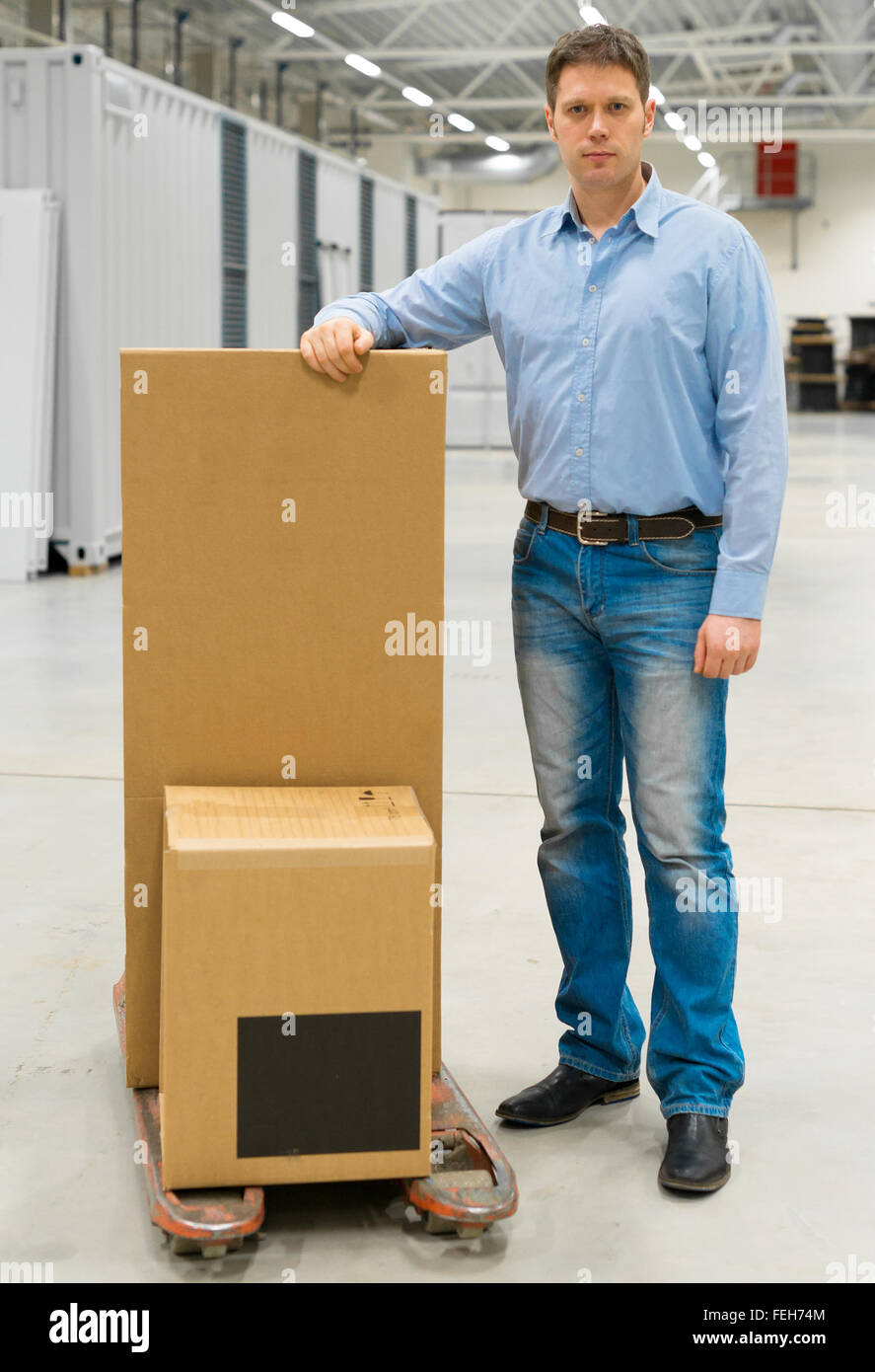 Männliche Arbeiter mit Boxen an Lager. Stockfoto