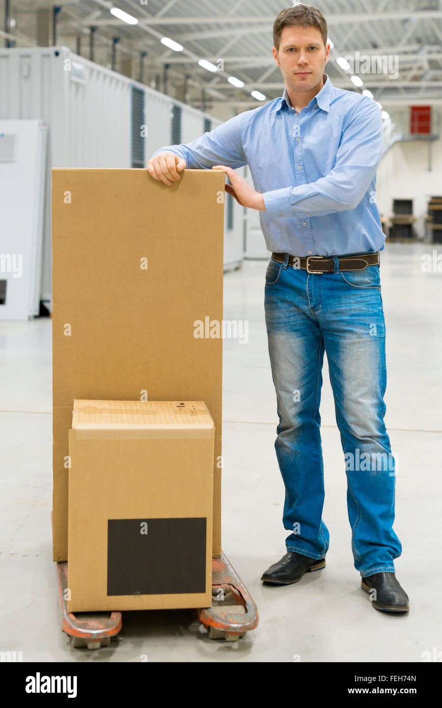 Männliche Arbeiter mit Boxen an Lager. Stockfoto
