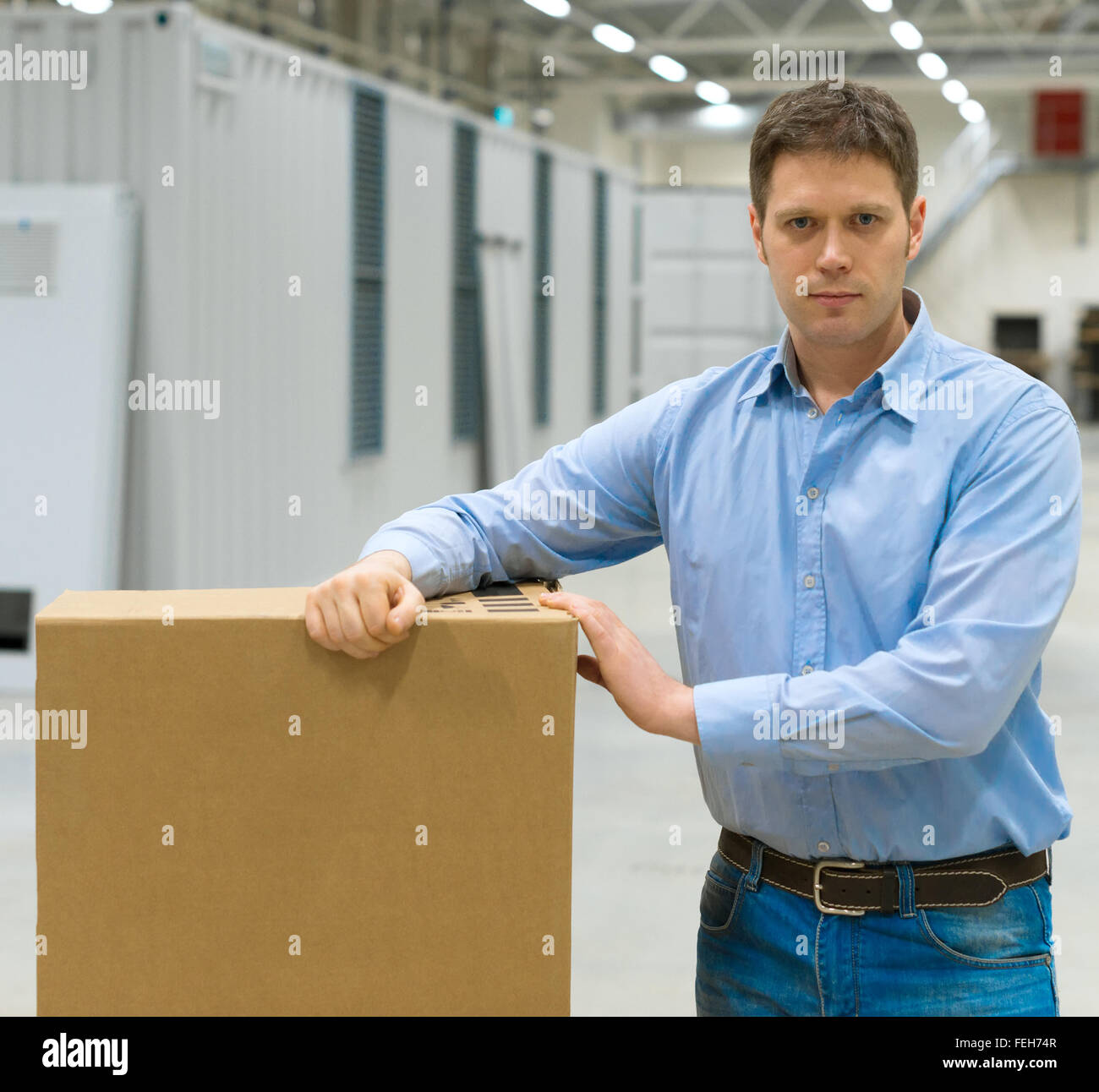 Männliche Arbeiter mit Boxen an Lager. Stockfoto