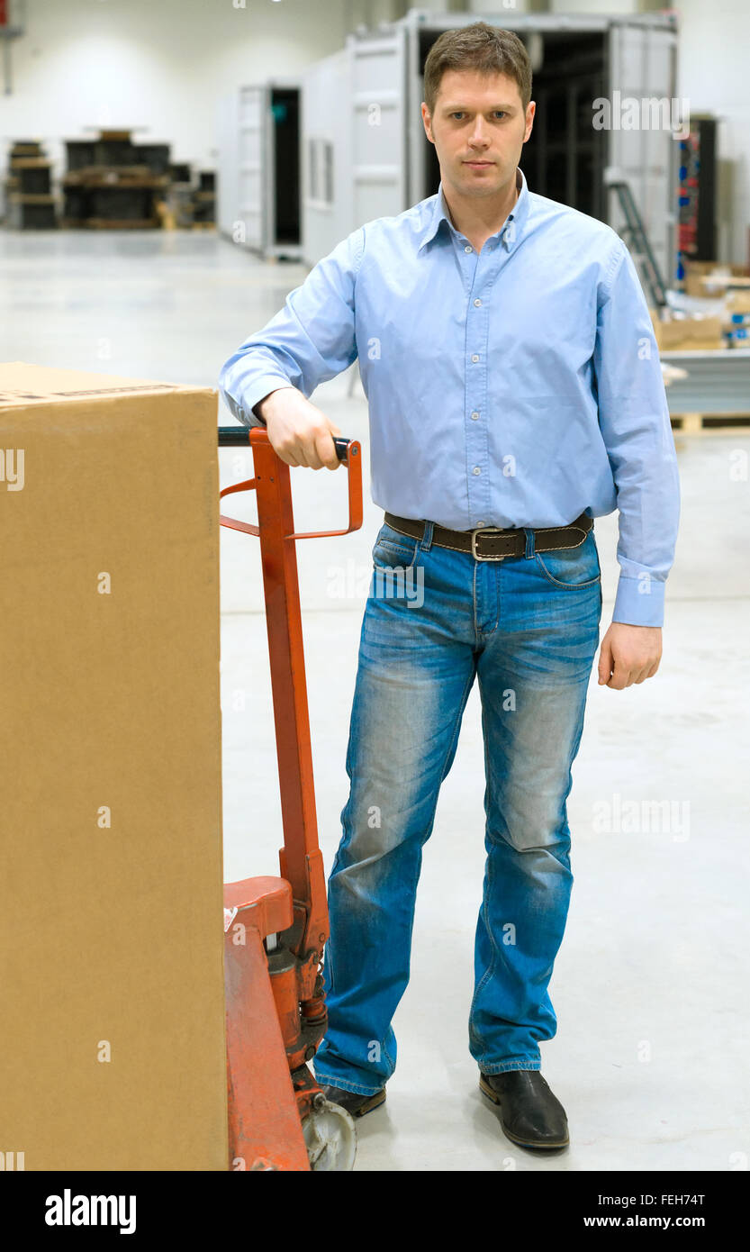 Männliche Arbeiter mit Boxen an Lager. Stockfoto
