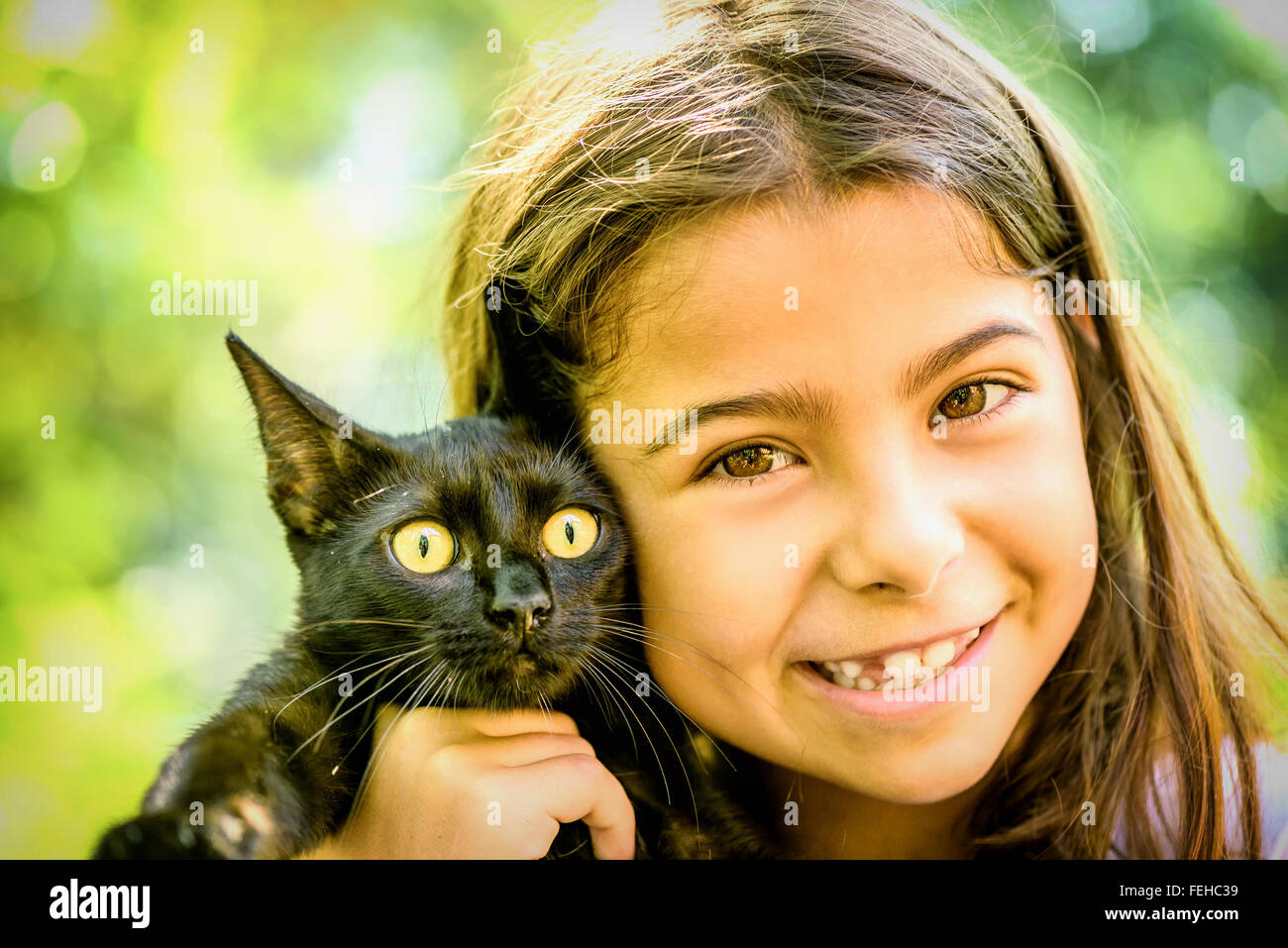 Porträt eines schönen Mädchens hielt eine schwarze Katze Stockfoto