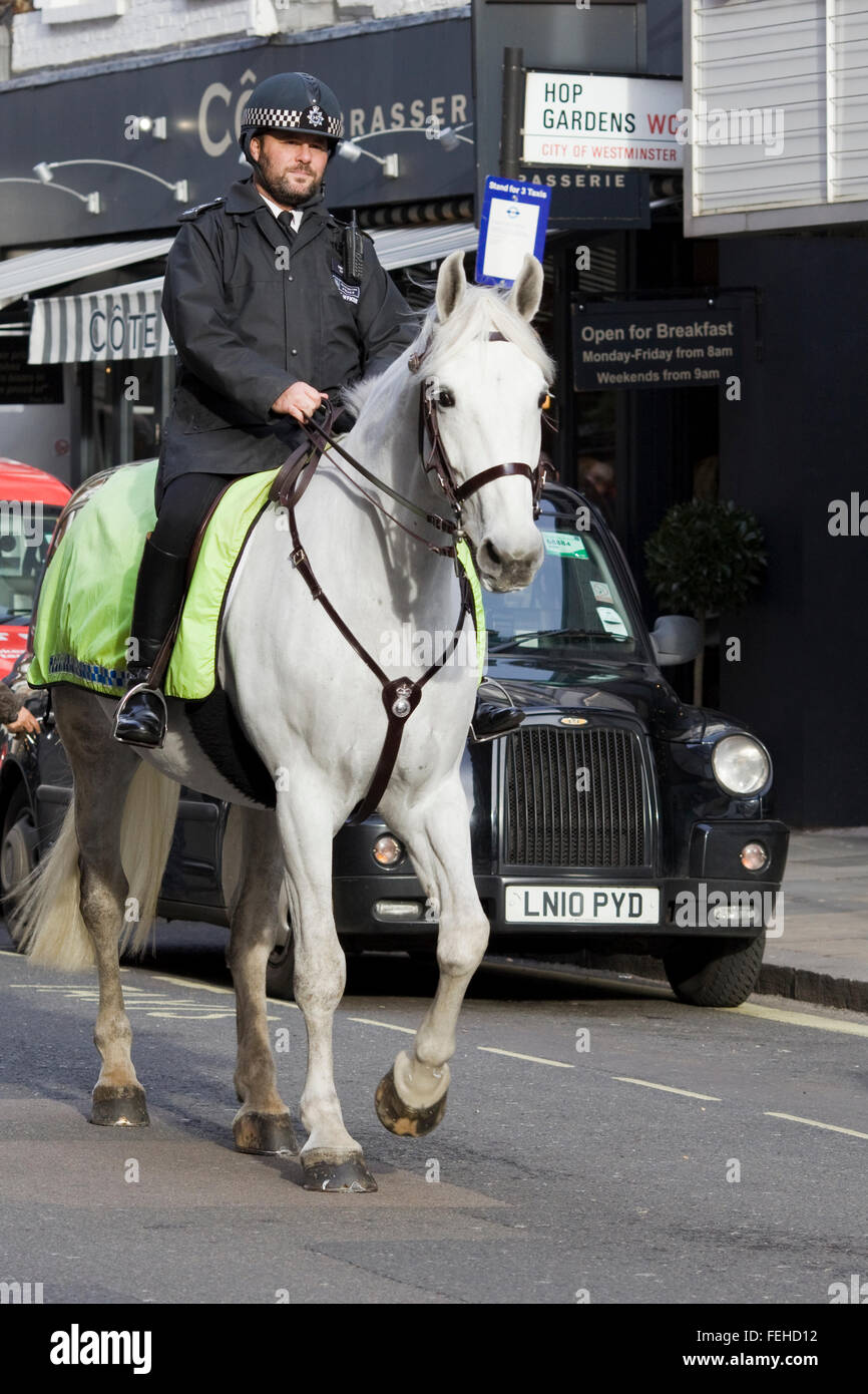 Berittene Polizisten vorbeigehen ein Black Cab-London Stockfoto