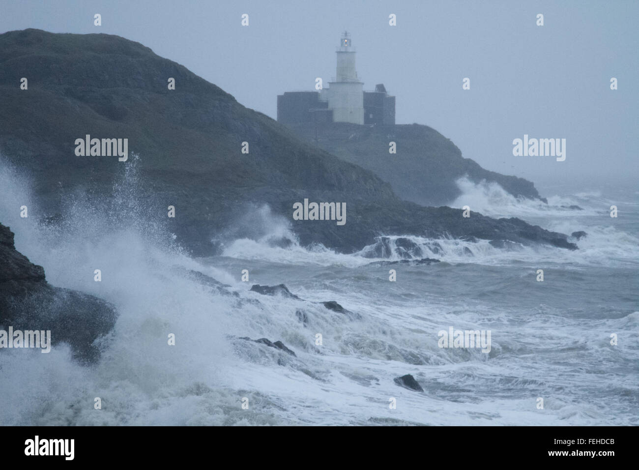Swansea, Großbritannien. 7. Februar 2016. Riesige Wellen Peitschen die Küste in der Nähe von Swansea, mit Blick auf Mumbles Leuchtturm als Sturm Imogen Ansätze. Bildnachweis: Andrew Bartlett/Alamy Live-Nachrichten. Stockfoto