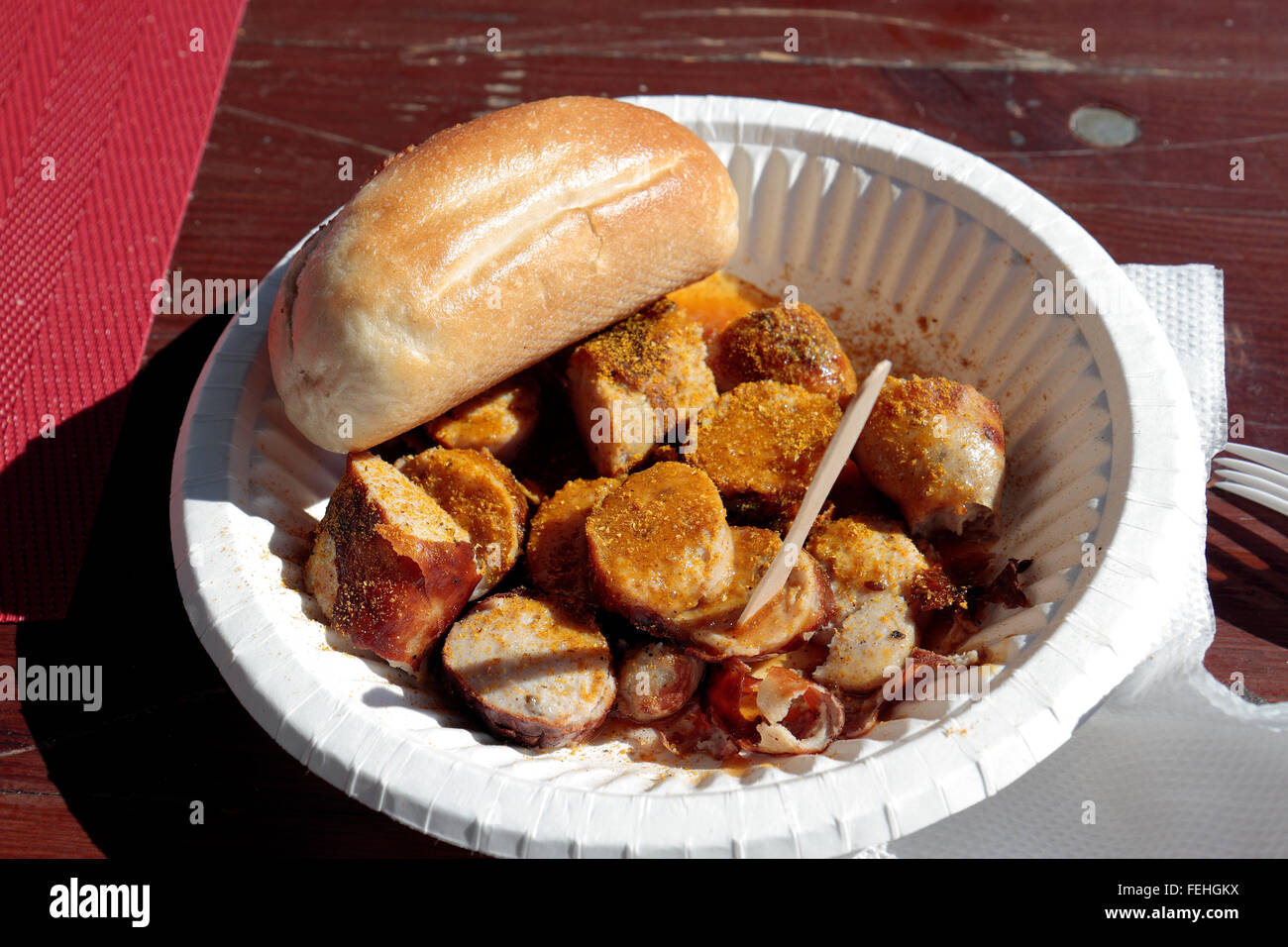 Curry-Pulver bedeckt Wurst und Brötchen in einen Papierschacht in Helsinki, Finnland. Stockfoto