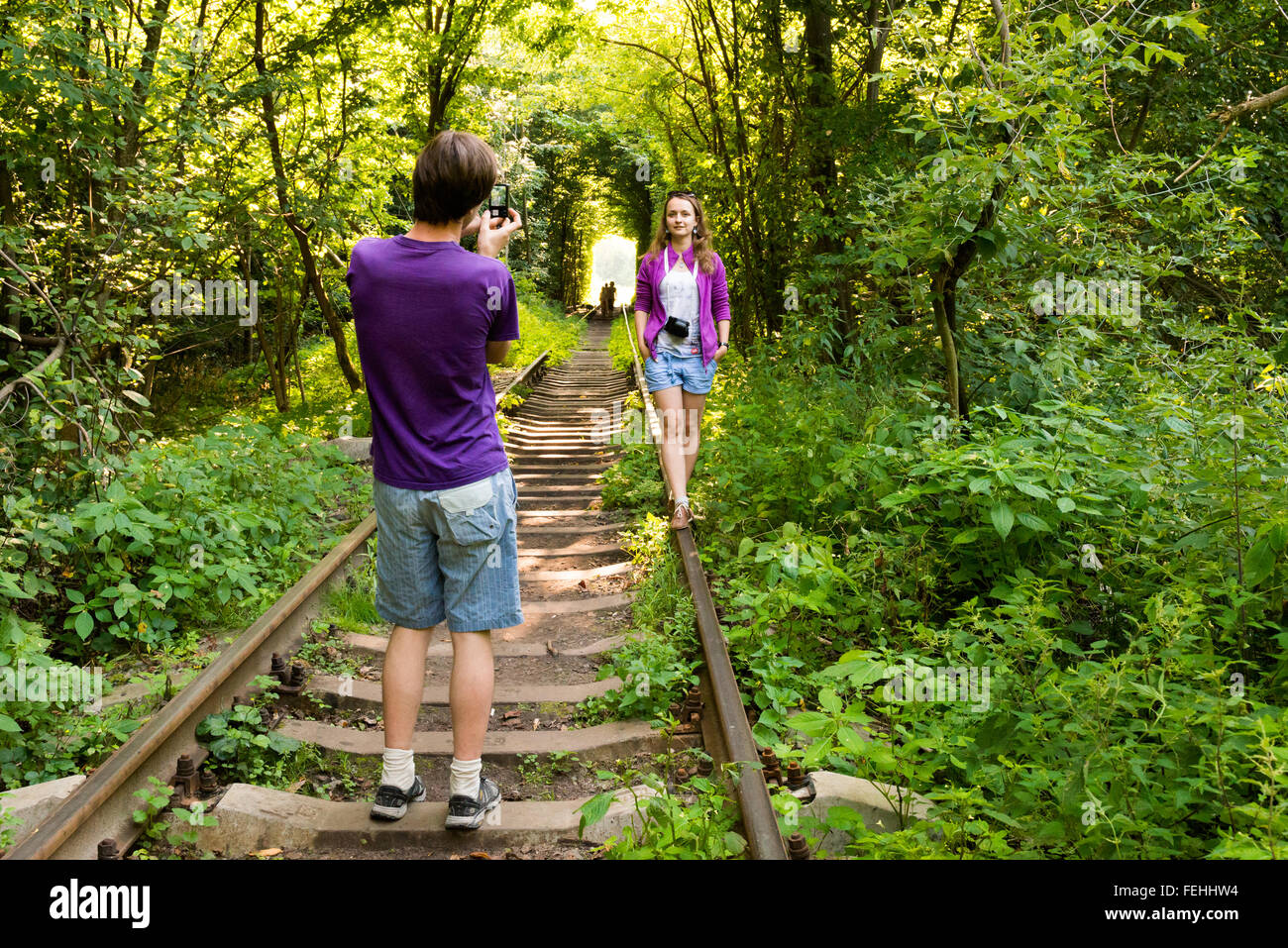 Touristen fotografieren in den Tunnel of Love - einen natürlichen Tunnel gebildet in den Wald, Klevan, Region Rovno, Ukraine Stockfoto