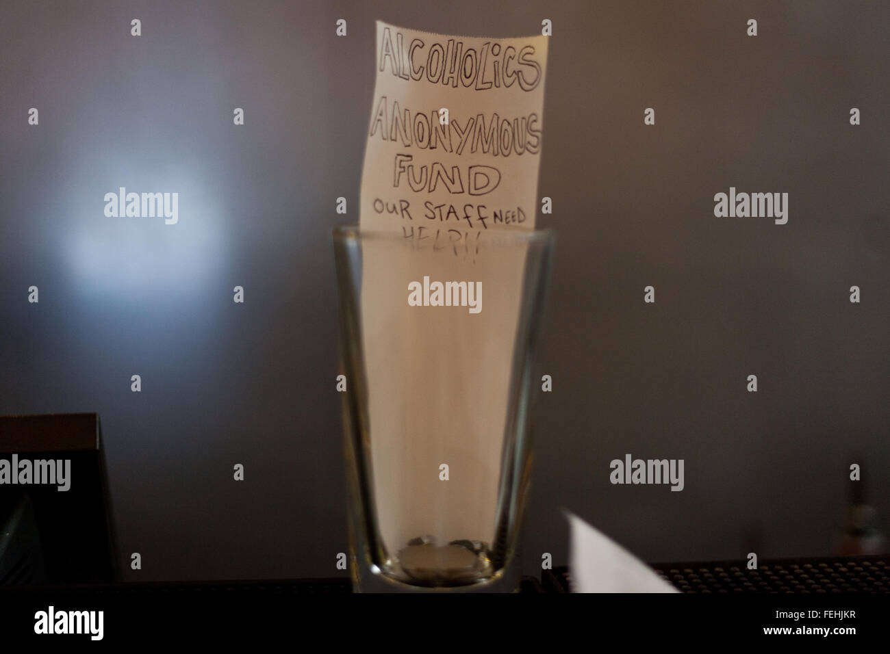 "Alkoholiker anonyme Fonds" geschrieben auf Papier innen Tip Jar auf Bar in London Veranstaltungsort. Stockfoto