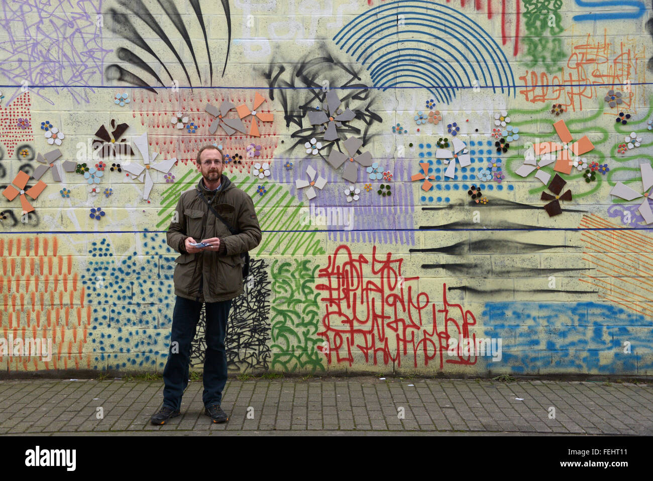 Brüssel, Belgien. 28. Januar 2016. Reiseleiter Bert de Bisschop steht vor einer bunten Wand im Stadtteil Molenbeek in Brüssel, Belgien, 28. Januar 2016. Er führt regelmäßig Touristen durch das Viertel, welches nach den Anschlägen in Paris am 13. November 2016 diskreditiert wurde. Nach den Anschlägen wurde bekannt, dass einige der Verdächtigen in Molenbeek gelebt hatte. Foto: GIOIA FORSTER/Dpa/Alamy Live News Stockfoto