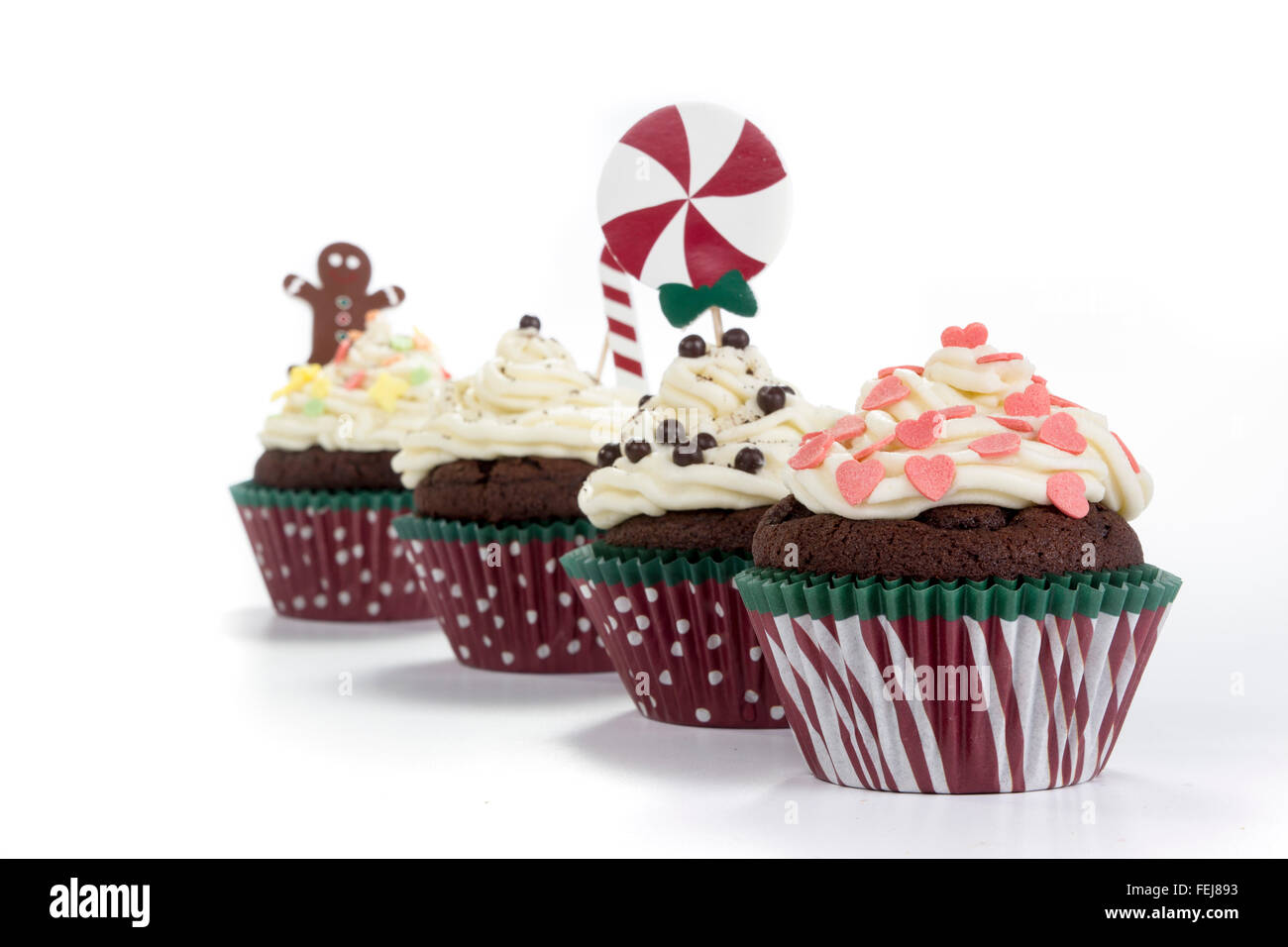 köstliche Schokoladen-Muffins mit Creme farbigen Belag isoliert auf weißem Hintergrund Stockfoto
