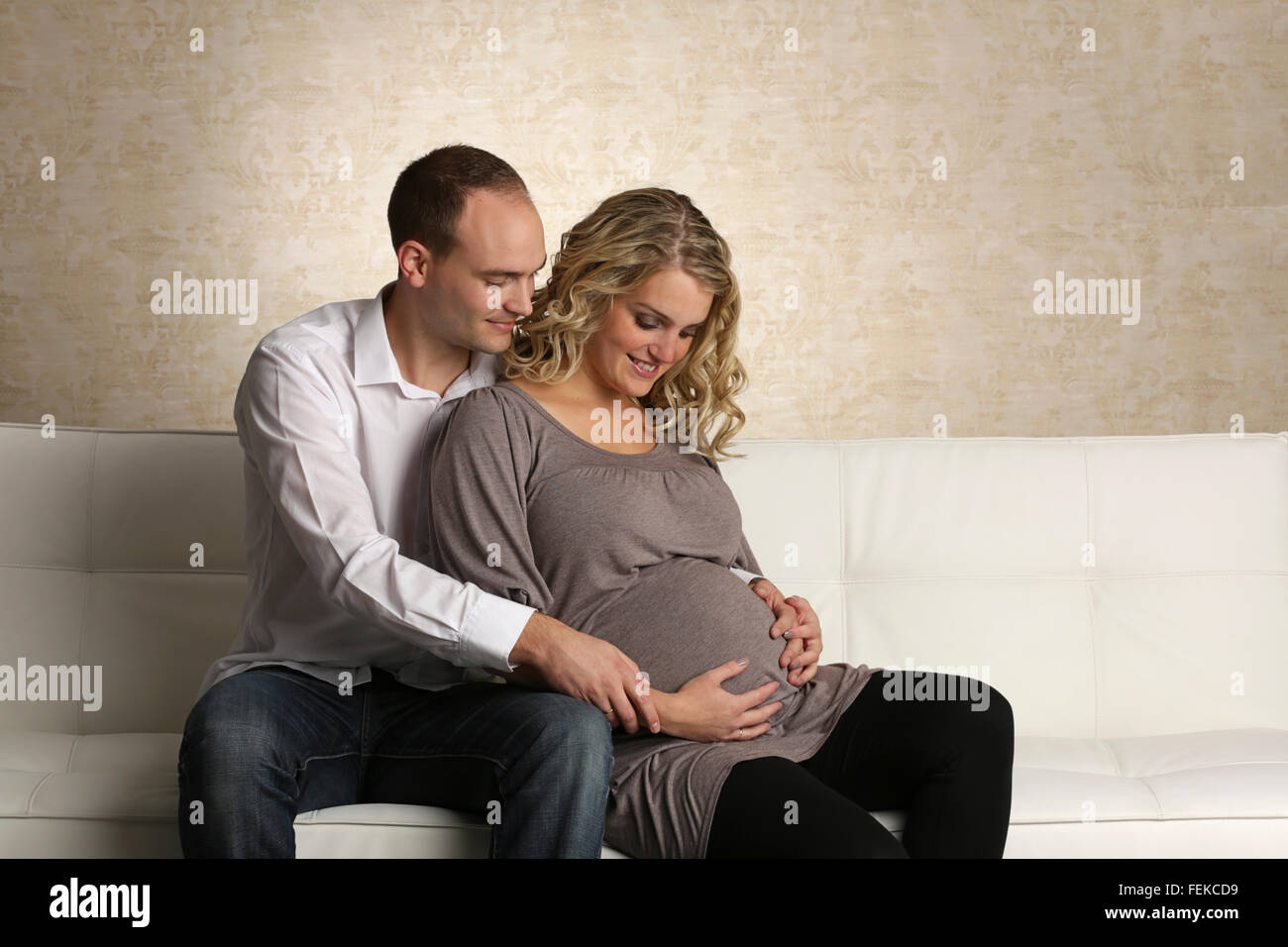 Schwangere Frau und Mann einander umarmen Stockfoto