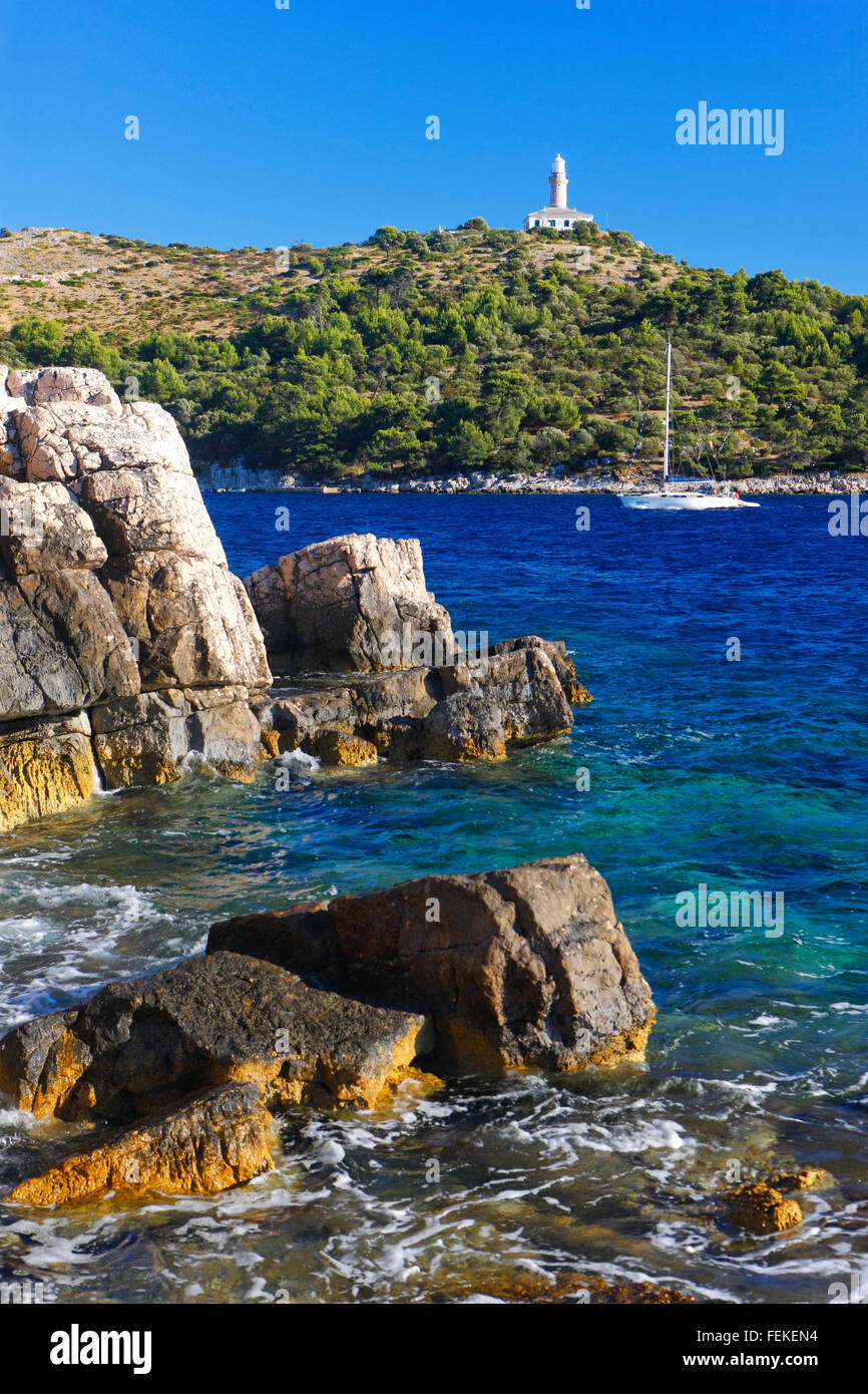 Insel Lastovo, Struga Leuchtturm oben auf dem Hügel und Segelboot unter Stockfoto