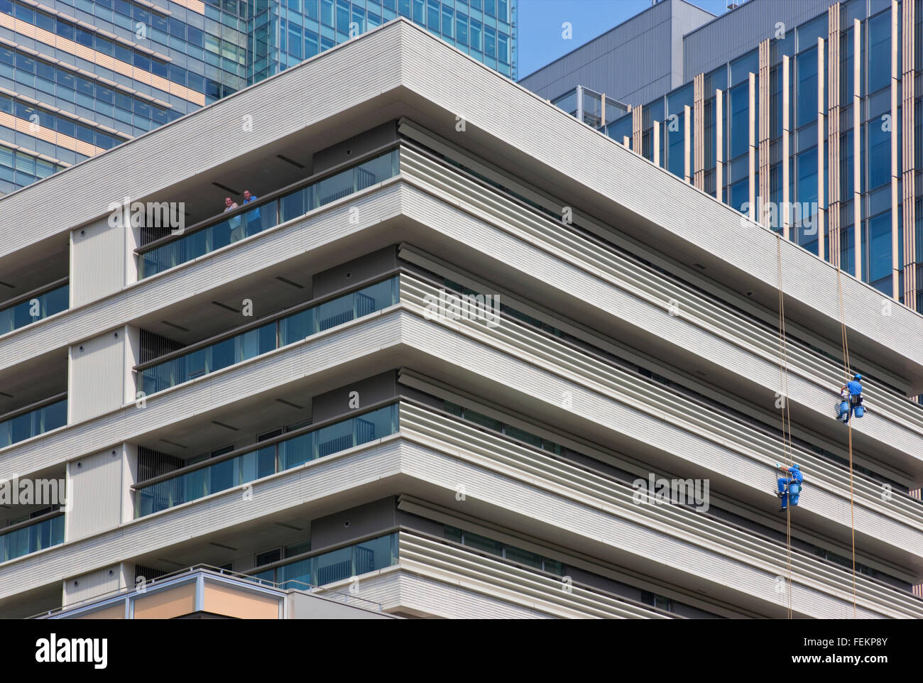 Wartungspersonal hängen hoch über der Straße während der Reinigung der Midtown Tokyo Komplex im gehobenen Stadtteil Roppongi Stockfoto