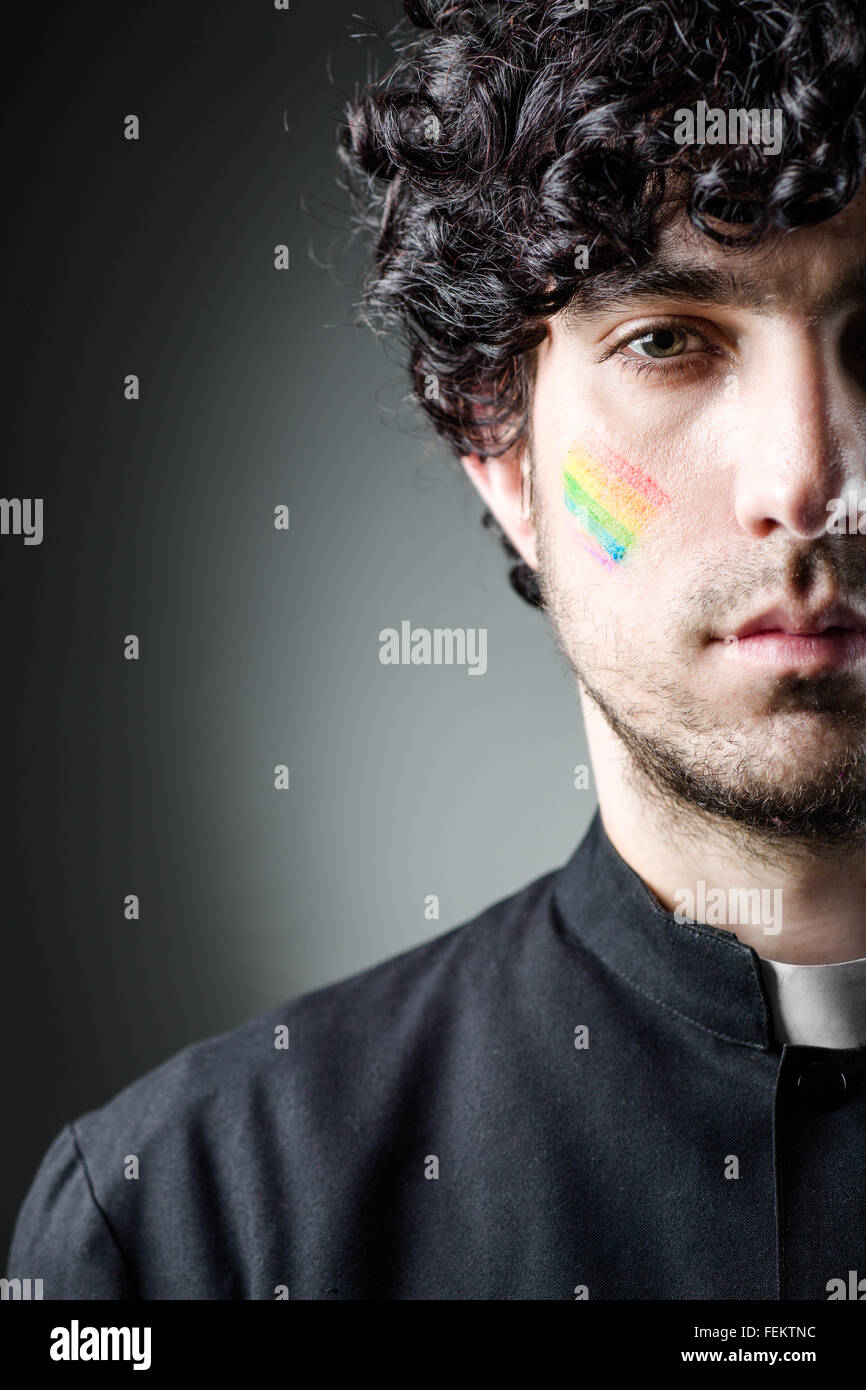 Schwule Priester mit Regenbogen Farbe auf die Wange Stockfoto