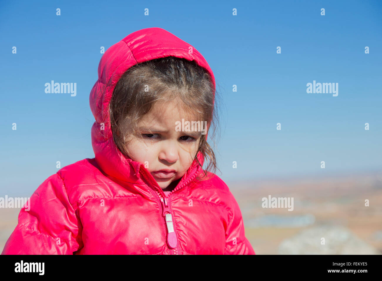 Porträt der niedliche kleine Mädchen leider Blick in die Kamera. Blauen Himmel im Hintergrund. Bokeh. Stockfoto