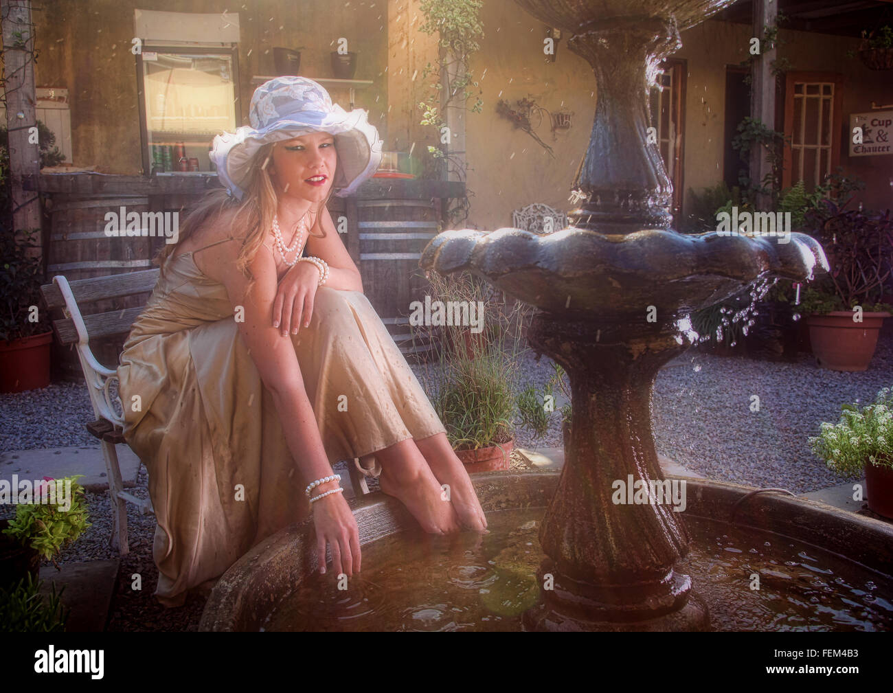 Eine schöne junge blonde Frau ist eine Pause von der Hitze des Sommers und ruhen ihre Wunde Füße im kühlen Wasser eines Wasser-feat Stockfoto