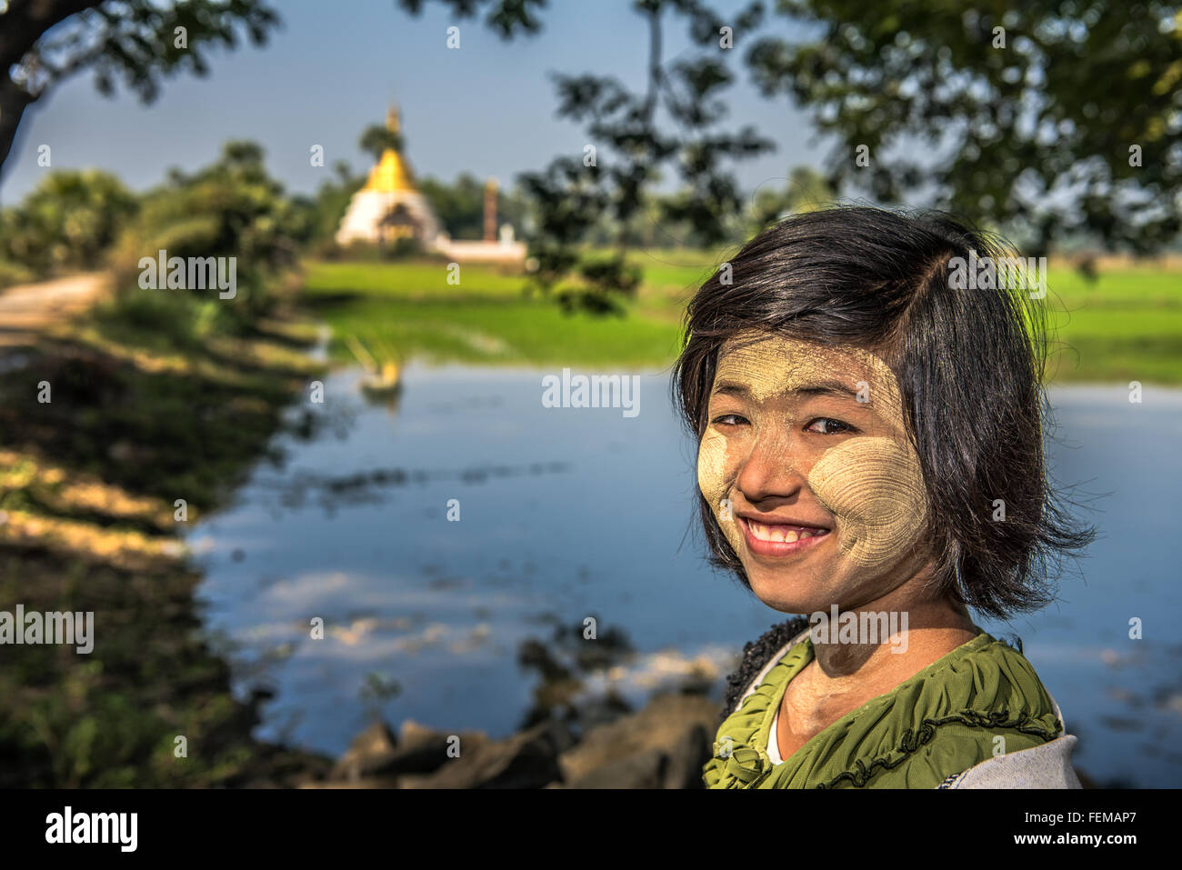 Porträt eines jungen burmesischen Mädchens in der Nähe einer buddhistischen Stupa mit Thanaka im Gesicht Stockfoto