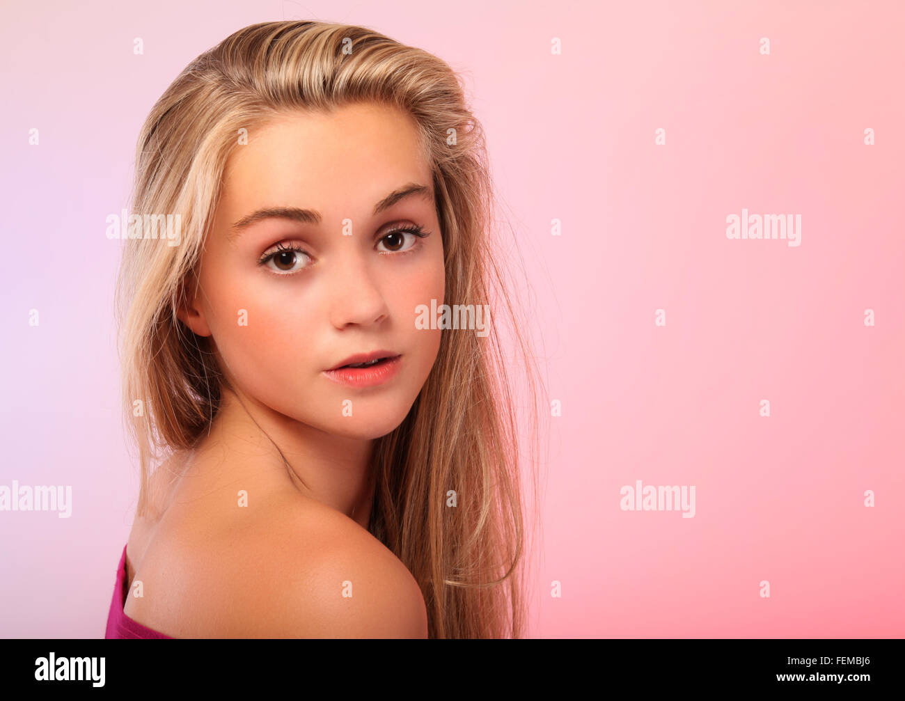 Eine schöne junge Teen blond Foto in einem Studio mit weichen rosa Hintergrund. Stockfoto
