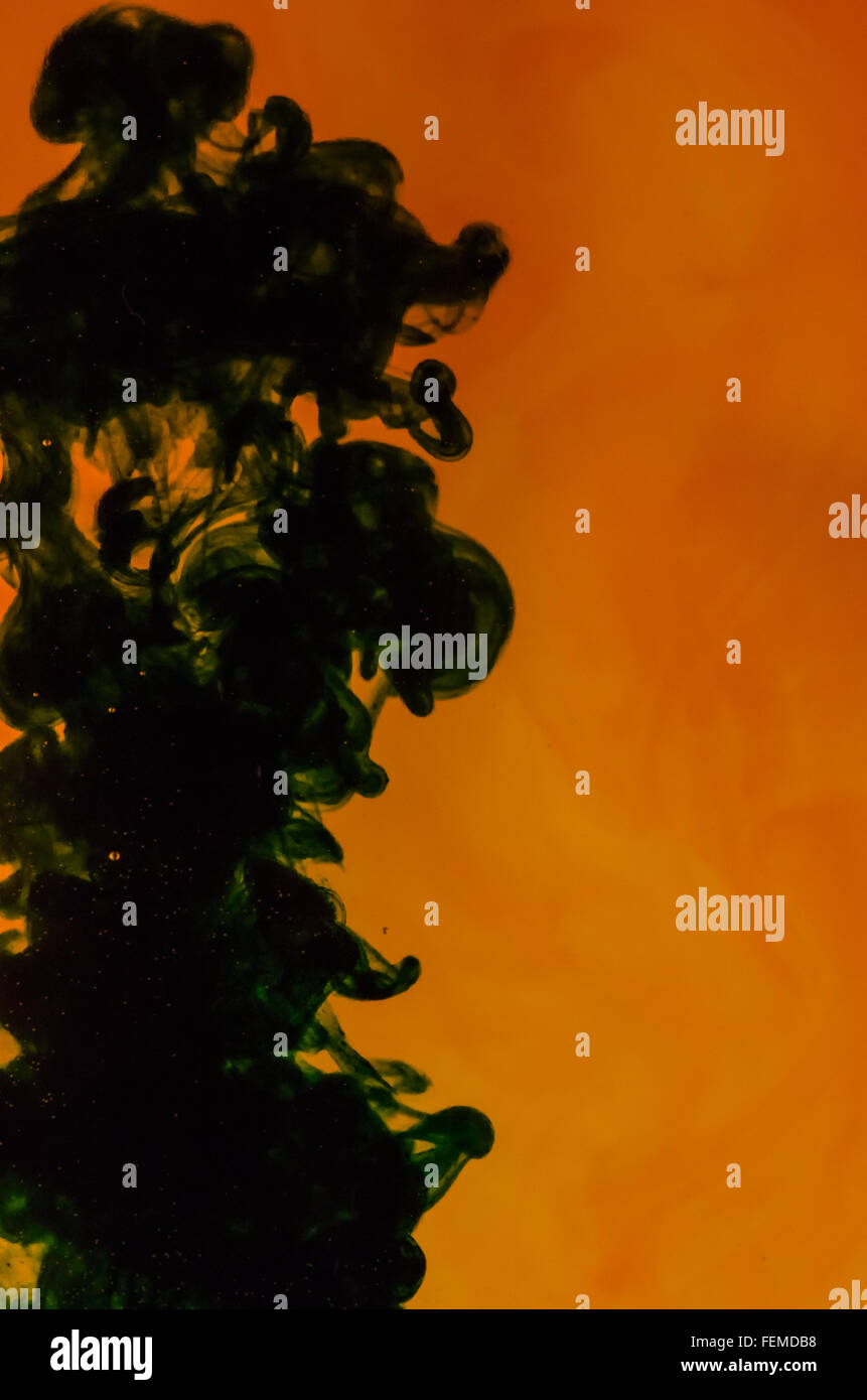 Schwarz und orange abstrakte Farbe Wirbel Spritzer ins Wasser Stockfoto