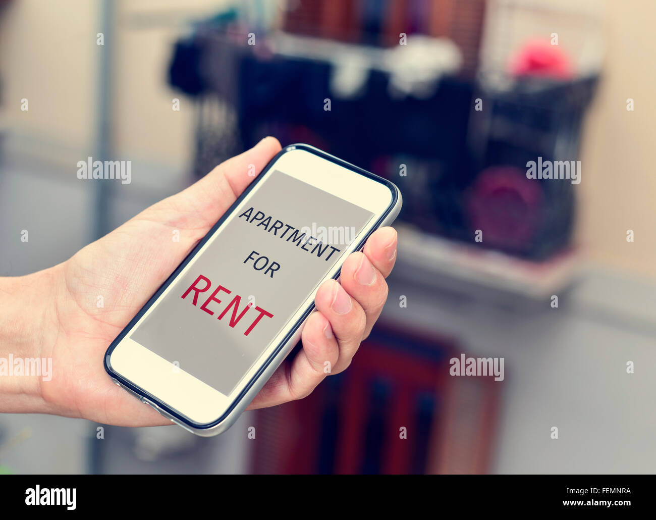 Nahaufnahme eines jungen Mannes mit einem Smartphone in der Hand mit der Text-Wohnung zu vermieten in seinem Bildschirm Stockfoto