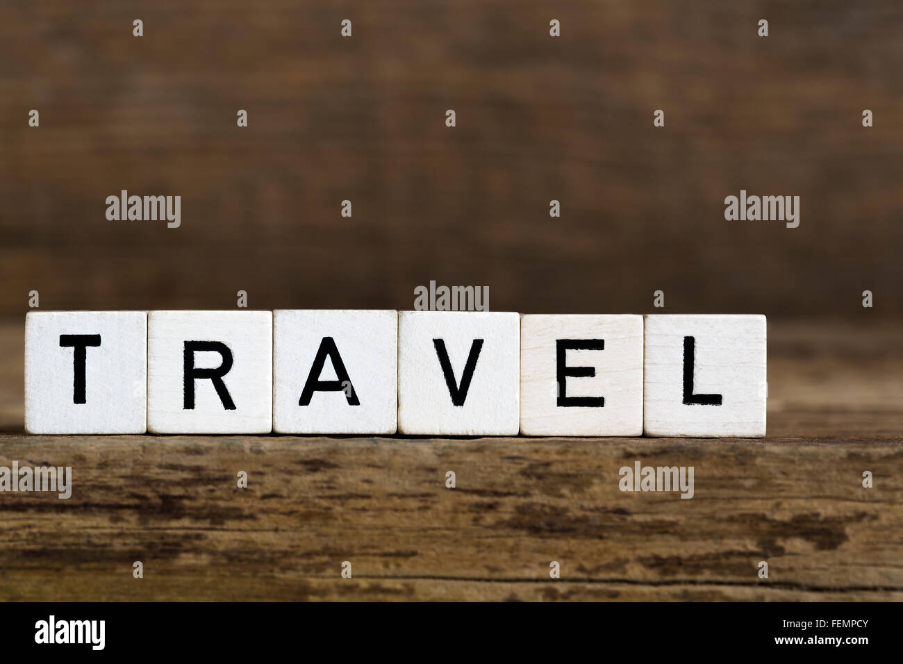 Das Wort Reisen im Würfel auf hölzernen Hintergrund geschrieben Stockfoto