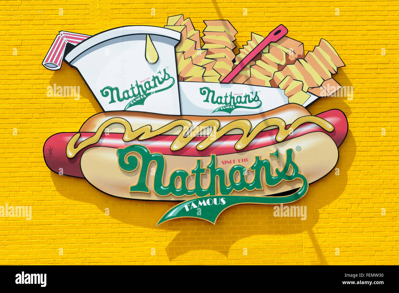 Nathan's Famous Inc. unterzeichnen auf gelb lackierten Ziegel Hintergrund, Coney Island, Brooklyn, New York City, USA Stockfoto