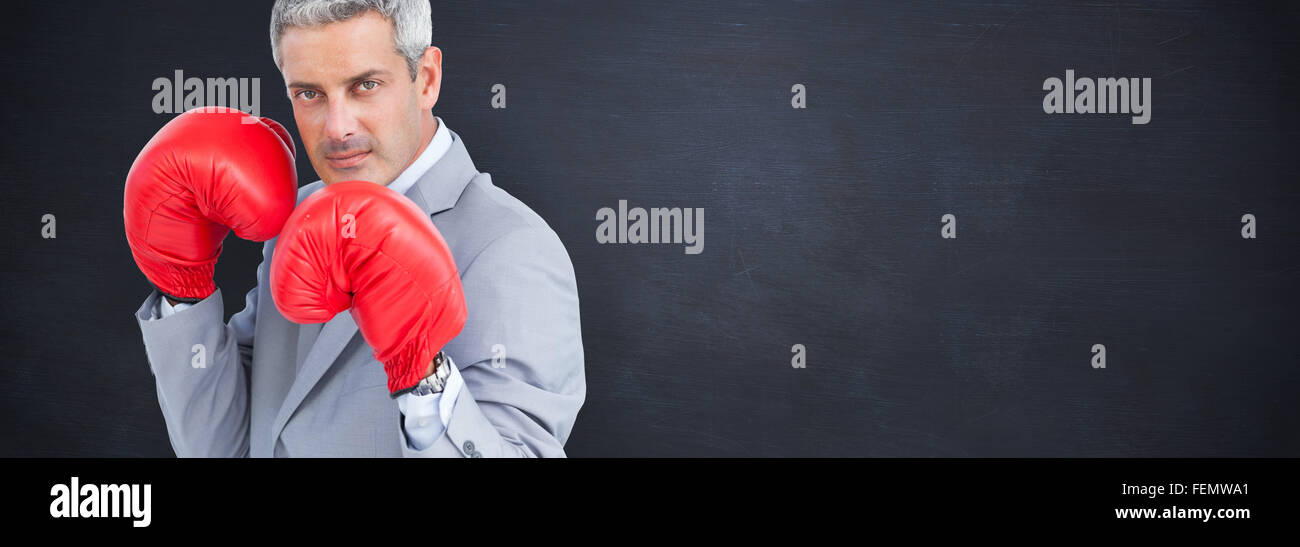 Zusammengesetztes Bild von harter Geschäftsmann mit Boxhandschuhen Stockfoto