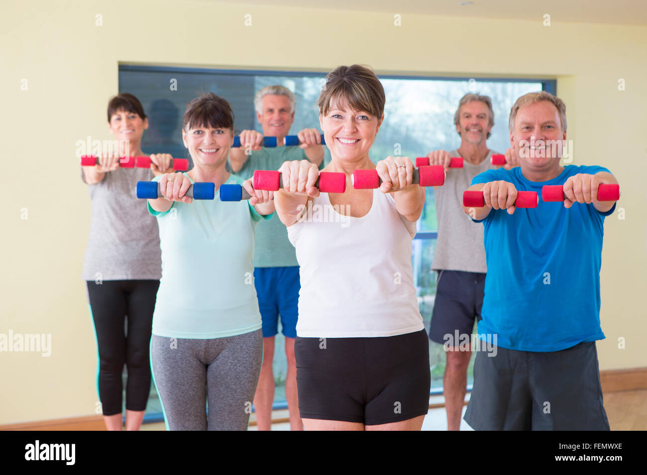 Gruppe von Senioren posiert mit Gewichten im Fitnessstudio Stockfoto