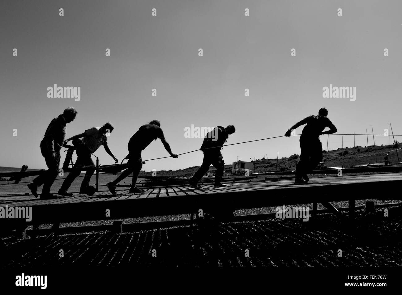 Männer schleppen ein Boot aus dem Meer Stockfoto