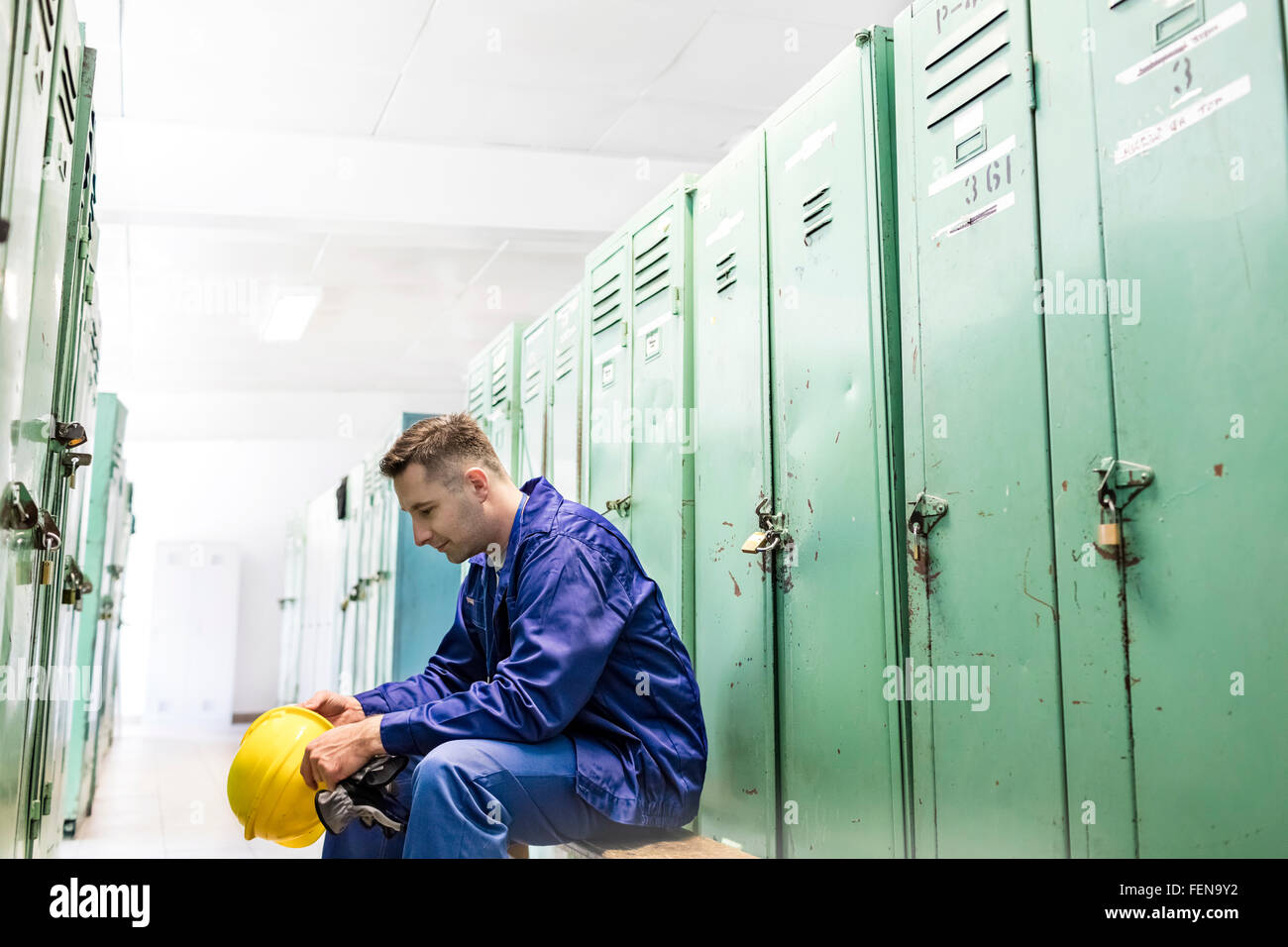 Arbeiter mit Schutzhelm in Umkleidekabine Stockfoto