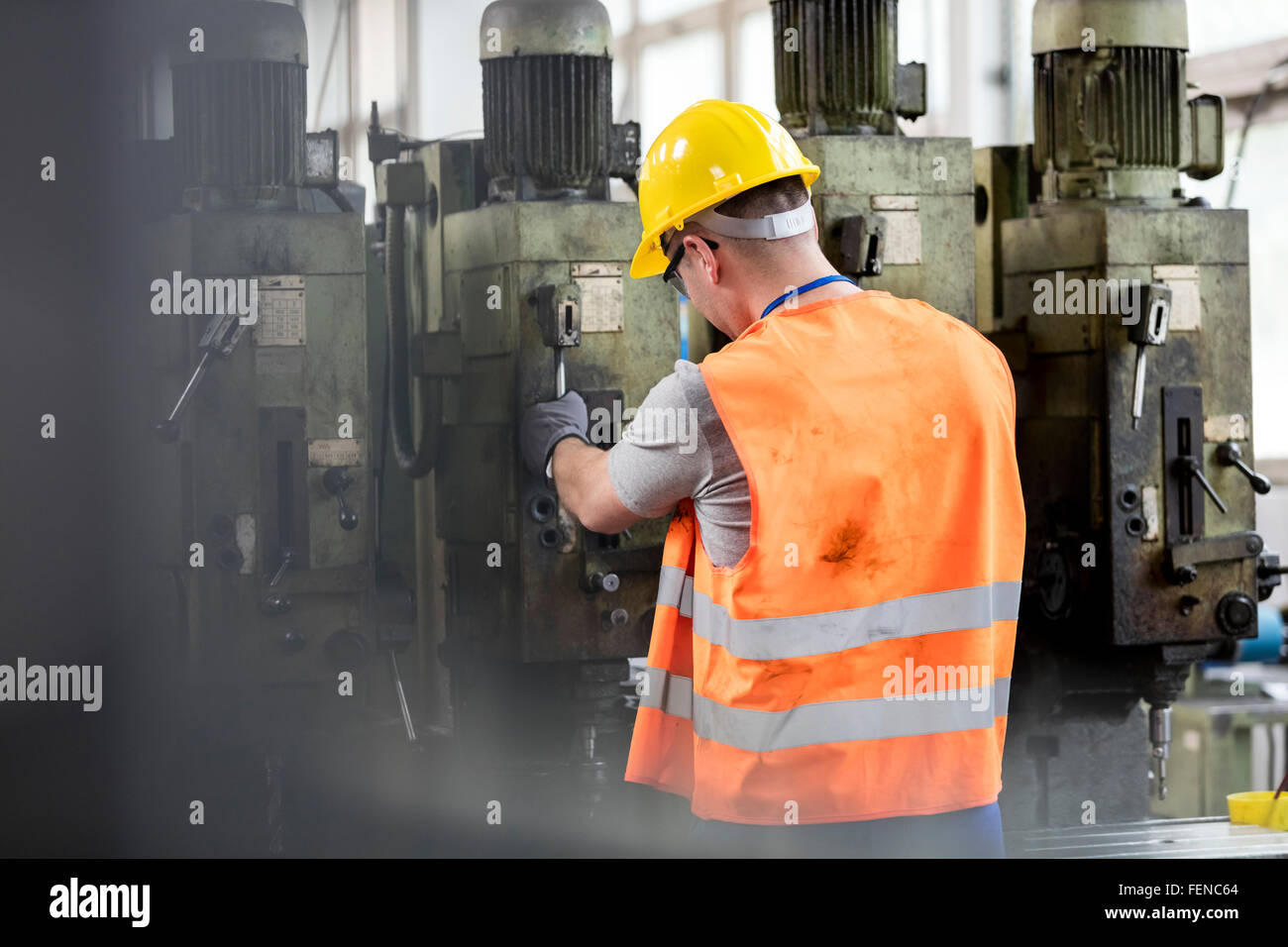 Arbeiter in Schutzkleidung, die Bedienung von Maschinen im Werk Stockfoto