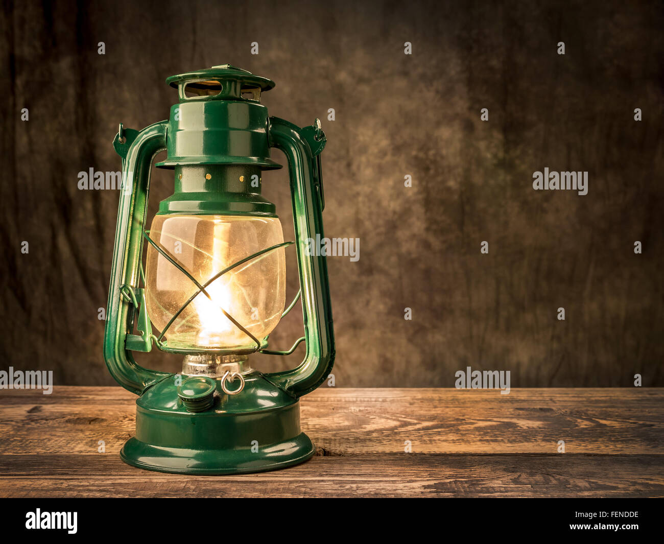 Vintage Öllampe leuchtet auf Holztisch auf dunklem Hintergrund Stockfoto