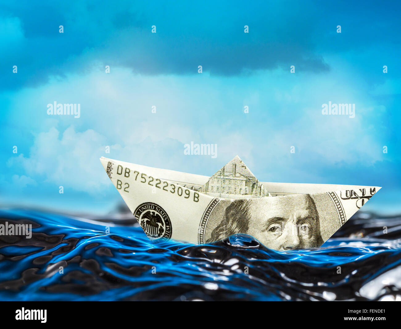 100-Dollar-Papierschiff auf den stürmischen Wellen schweben Stockfoto