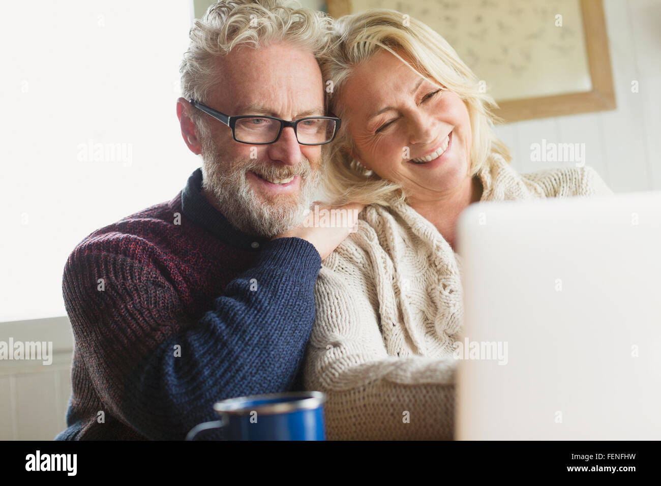 Lächelnde älteres Paar mit Laptop in der Küche Stockfoto