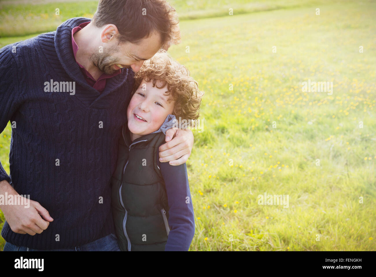 Vater umarmt Sohn im Feld Stockfoto