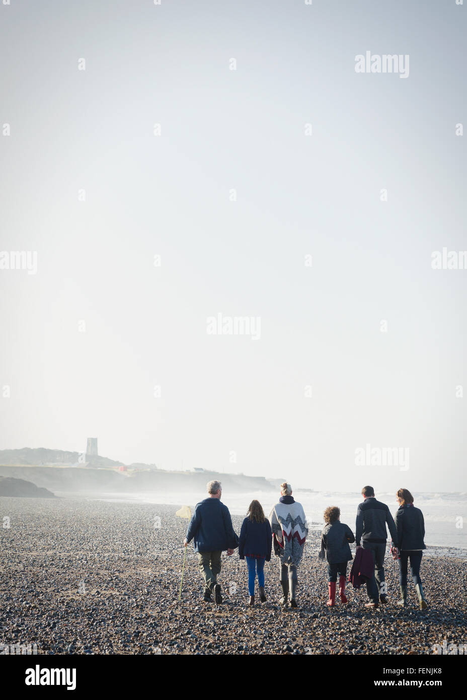 Mehr-Generationen-Familie Wandern am sonnigen Strand in Folge Stockfoto