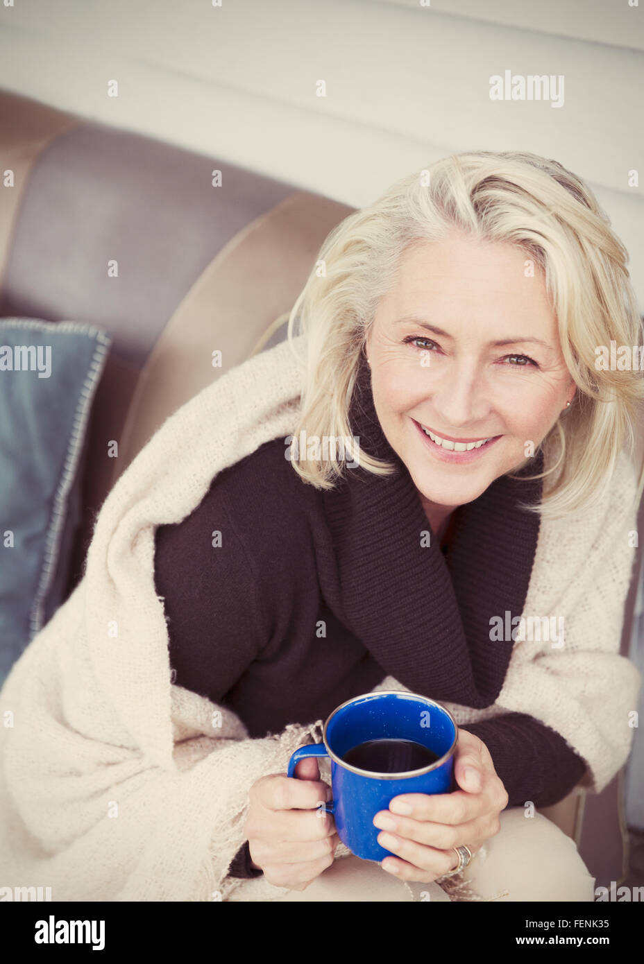 Porträt lächelnd senior Frau trägt Schal Kaffeetrinken auf Terrasse Stockfoto
