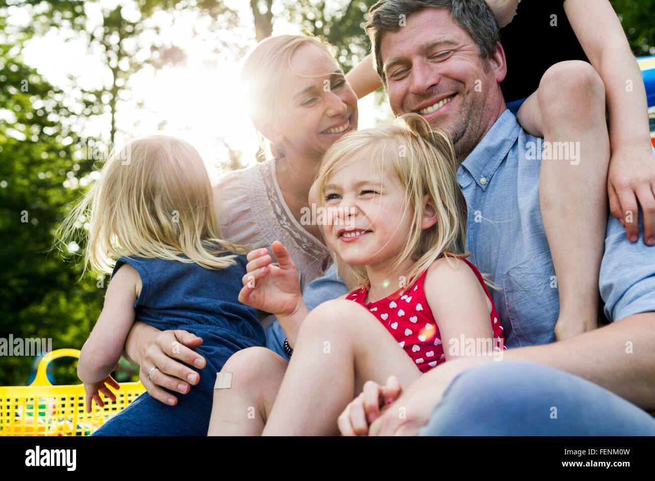 Glückliche Eltern und drei Töchter teilen Familien-Picknick im park Stockfoto