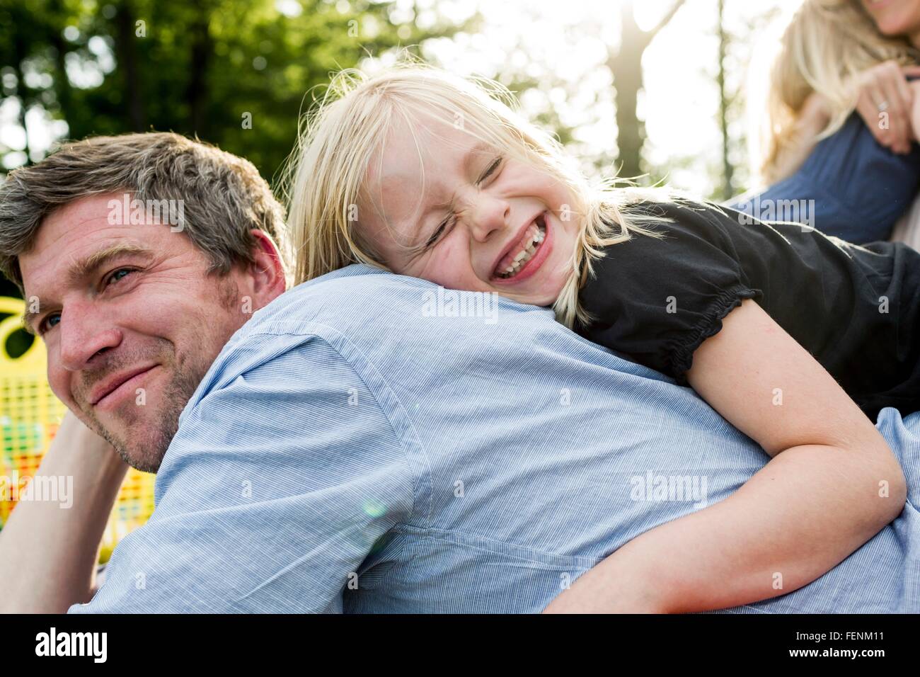 Mädchen umarmt Vater im park Stockfoto