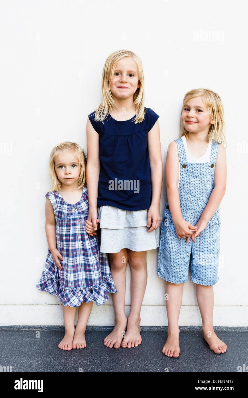 Porträt von drei jungen Schwestern, steht man vor der weißen Wand Stockfoto