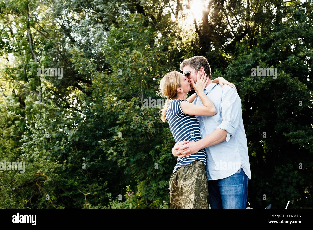 Paar Teilen leidenschaftlichen Kuss im park Stockfoto