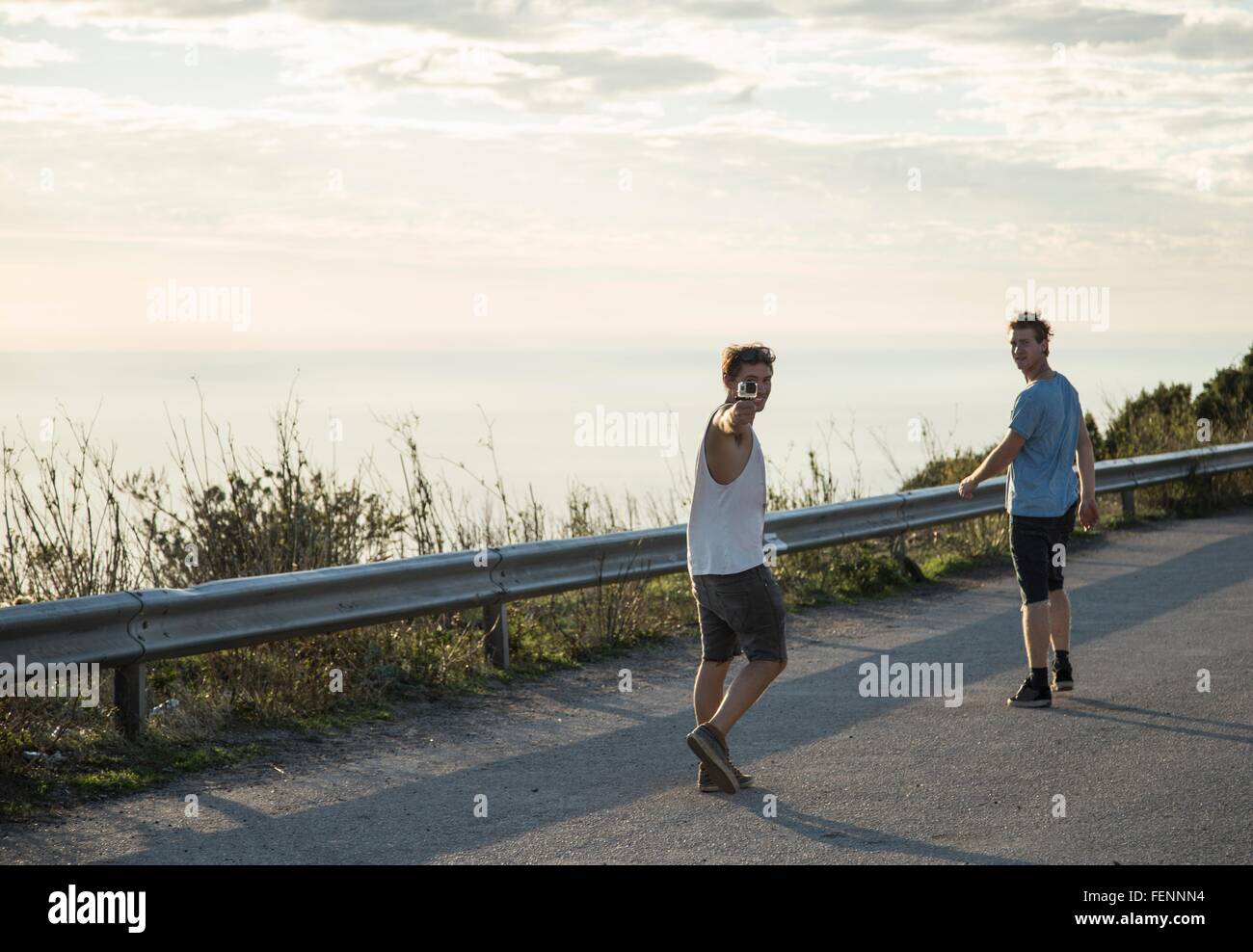 Voller Länge Rückansicht von jungen Männern auf Straße halten Kamera Blick auf Schulter, Alghero, Sardinien, Italien Stockfoto