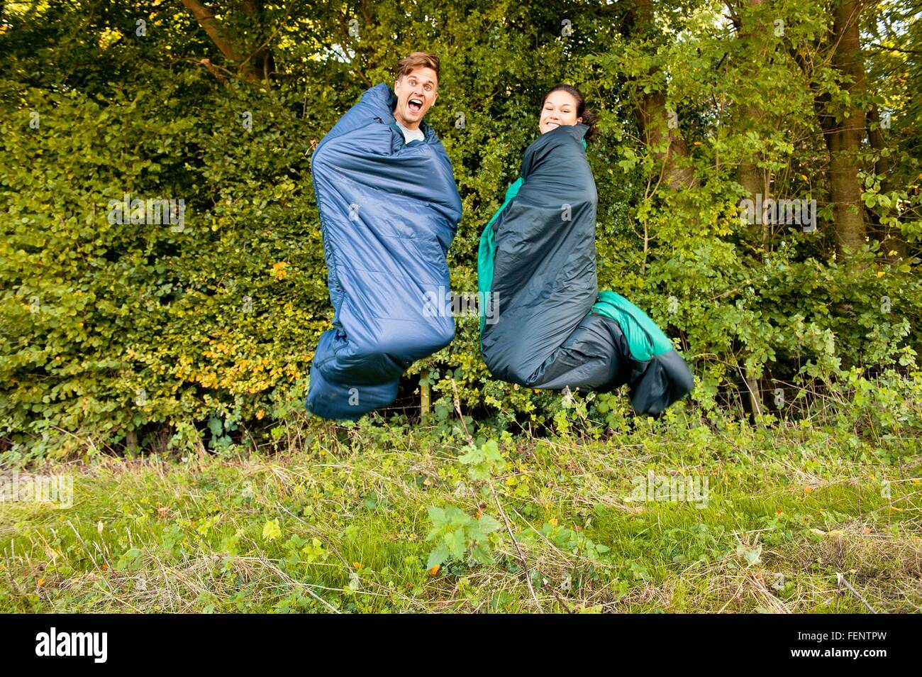 Junges Paar springen Luft in ihre Schlafsäcke Stockfoto