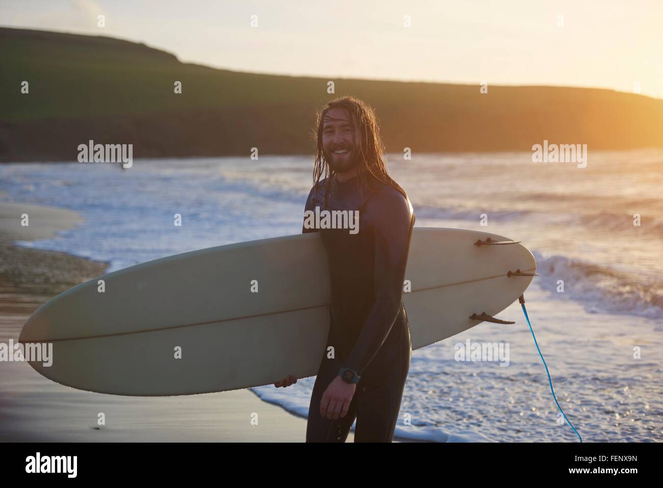Porträt des jungen männlichen Surfer mit Surfbrett am Strand, Devon, England, UK Stockfoto