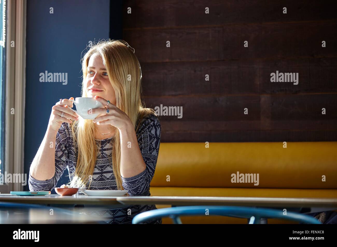 Junge Frau allein im Café Kaffee trinken Stockfoto
